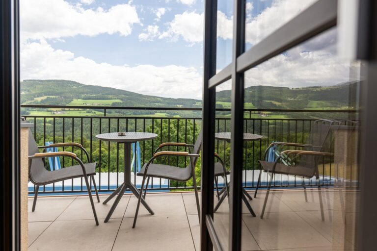 Balkon mit Tisch und Stühlen und Blick über die Hügel der Oststeiermark