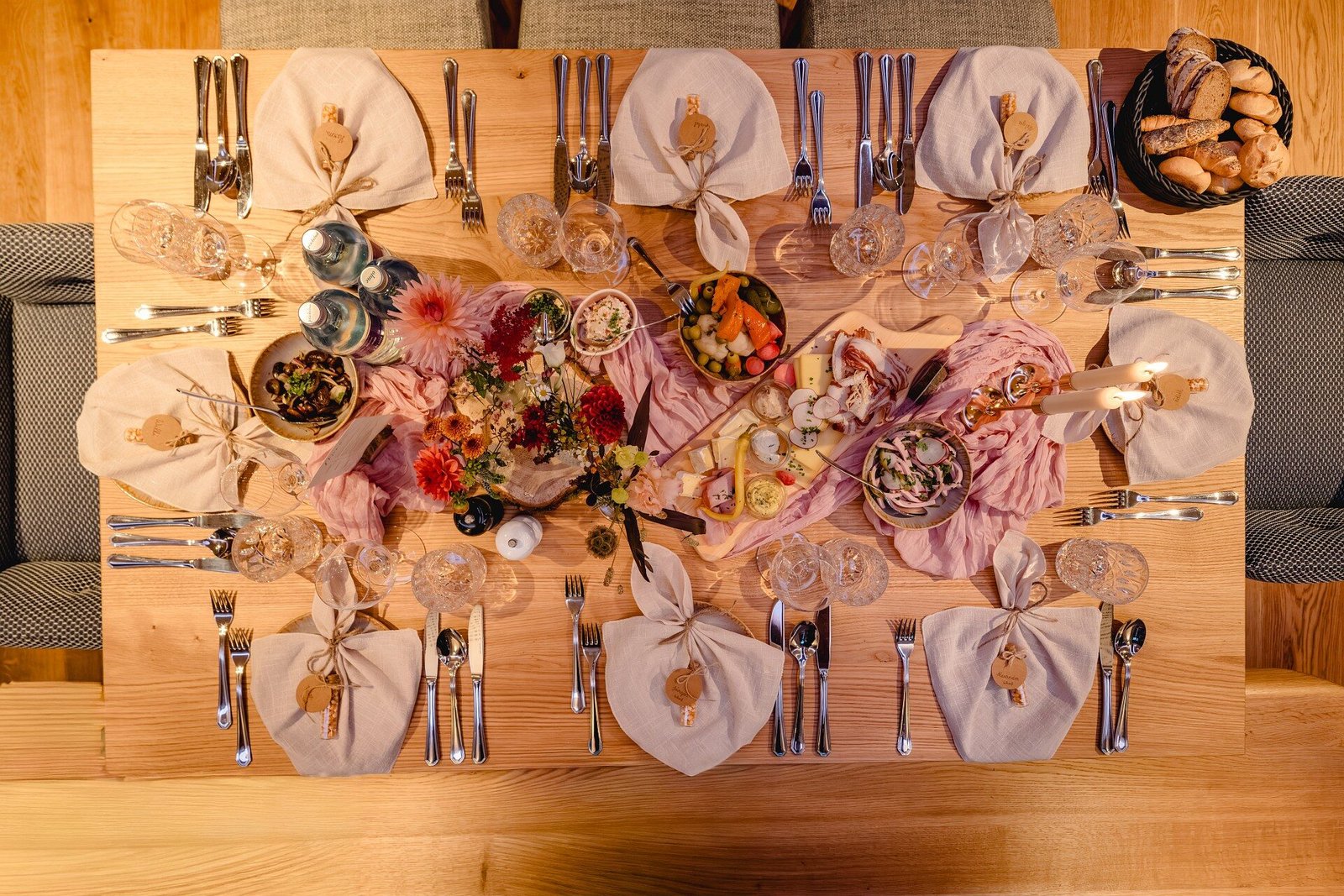 Aufsicht auf eine festlich gedeckte Tafel mit Blumen, Gläsern und Servietten