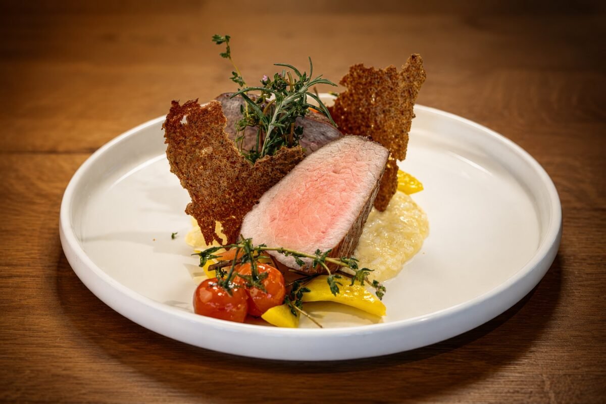 Rosa gebratenes Fleisch mit Kräuterkruste, Polenta und Gemüse